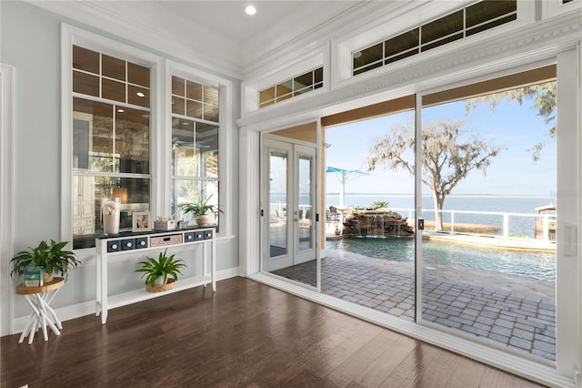 doorway featuring baseboards, ornamental molding, dark wood-type flooring, a water view, and french doors