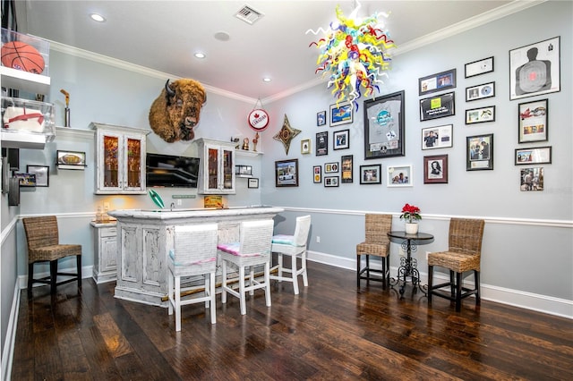 bar featuring indoor bar, dark wood finished floors, visible vents, ornamental molding, and baseboards