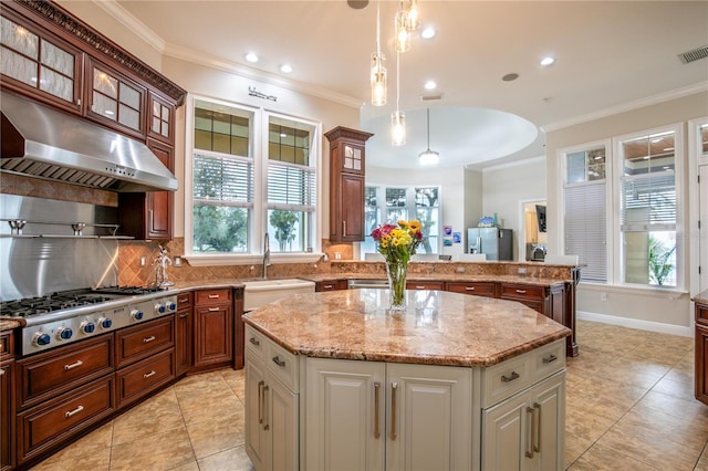 kitchen featuring crown molding, stainless steel gas cooktop, a kitchen island, a sink, and under cabinet range hood