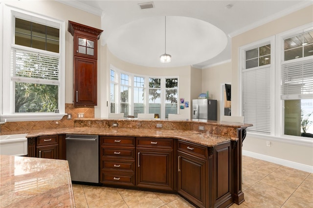 kitchen featuring pendant lighting, crown molding, visible vents, light stone countertops, and stainless steel fridge