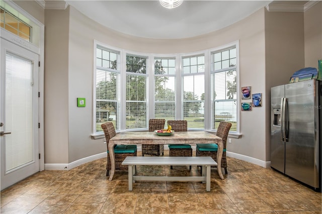 dining space with crown molding and baseboards