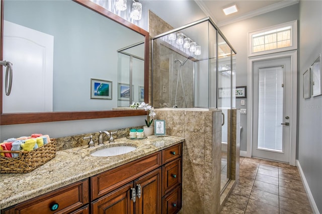 bathroom with vanity, baseboards, a shower stall, tile patterned floors, and crown molding