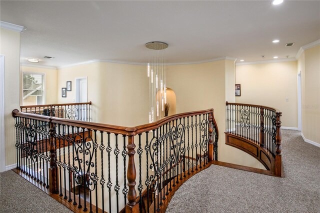 hall featuring carpet floors, baseboards, ornamental molding, and an upstairs landing