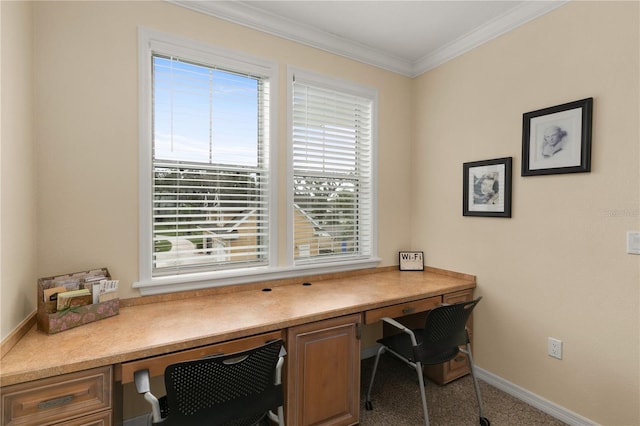 home office with ornamental molding, built in desk, a wealth of natural light, and baseboards