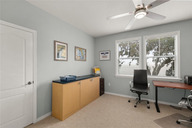 office area featuring baseboards, ceiling fan, and light colored carpet