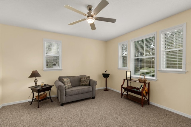 sitting room with baseboards, a healthy amount of sunlight, and light colored carpet