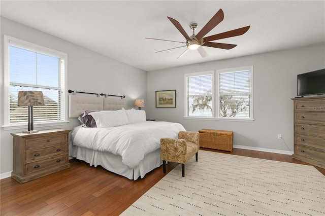 bedroom featuring a ceiling fan, baseboards, and wood finished floors