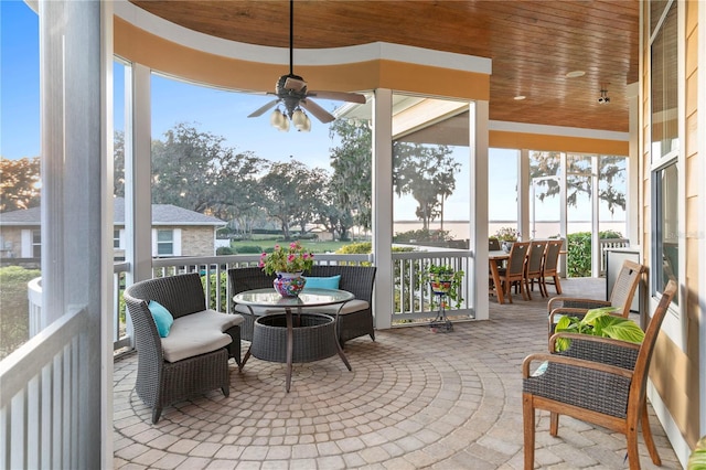 sunroom featuring wooden ceiling and a ceiling fan