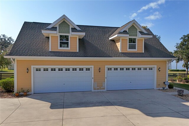 view of front facade featuring a shingled roof and a detached garage