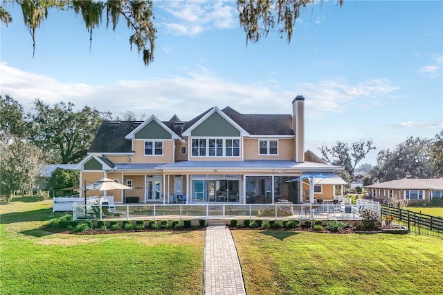 view of front of property featuring fence, a chimney, and a front lawn