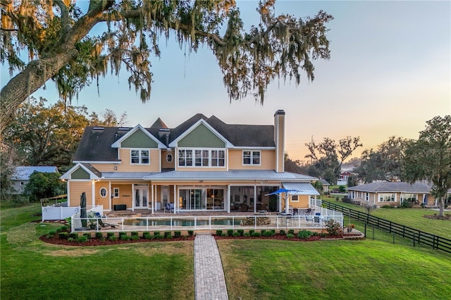 rear view of house with a patio area, a fenced backyard, a chimney, and a yard