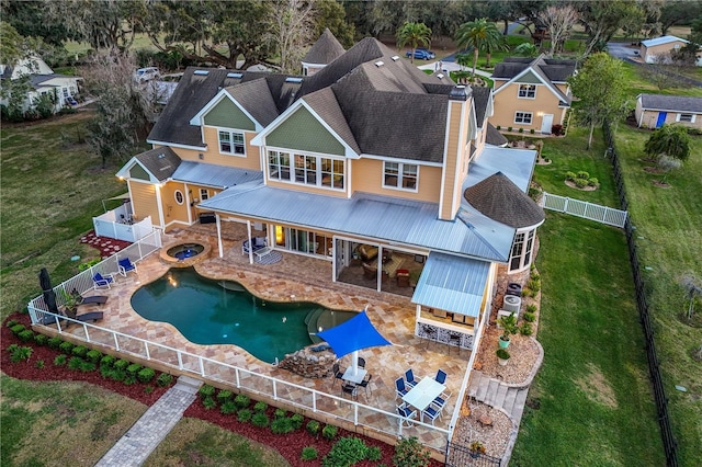 rear view of property featuring an in ground hot tub, a fenced backyard, an outdoor fire pit, and a patio