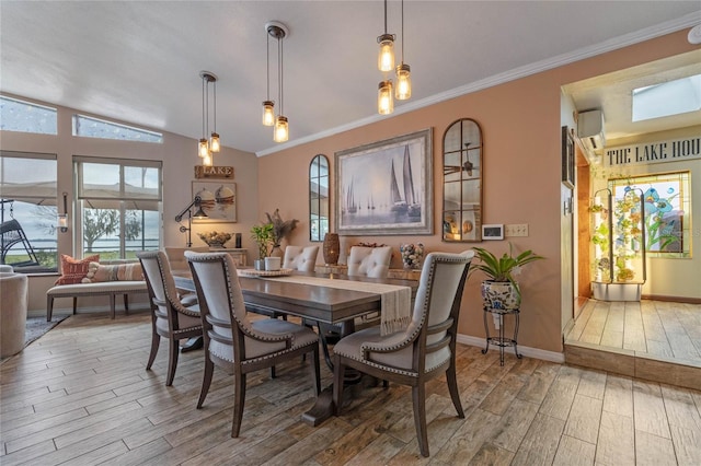 dining area with wood-type flooring, ornamental molding, and vaulted ceiling