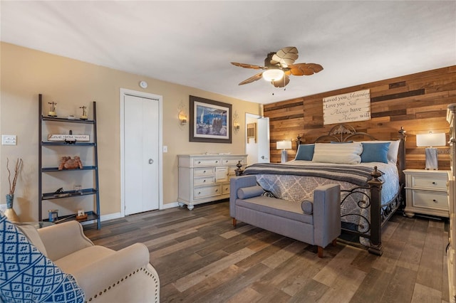 bedroom featuring ceiling fan, dark hardwood / wood-style floors, and wood walls