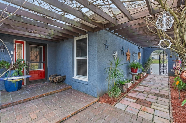 property entrance with a pergola