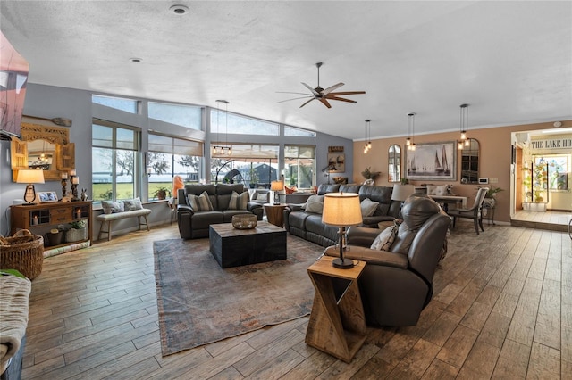 living room featuring ceiling fan, dark wood-type flooring, a textured ceiling, and vaulted ceiling