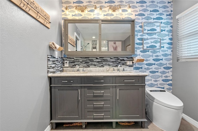 bathroom with vanity, toilet, and decorative backsplash