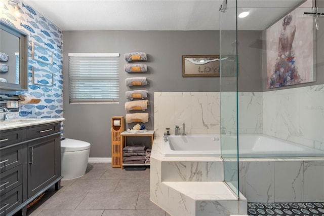 bathroom with vanity, tile patterned flooring, tiled bath, and toilet