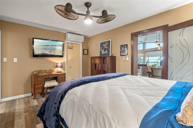 bedroom with ceiling fan, hardwood / wood-style floors, and a wall unit AC