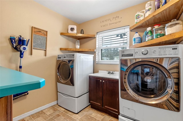 washroom featuring cabinets, sink, and independent washer and dryer