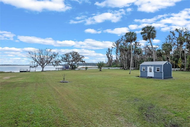 view of yard with a storage shed and a water view