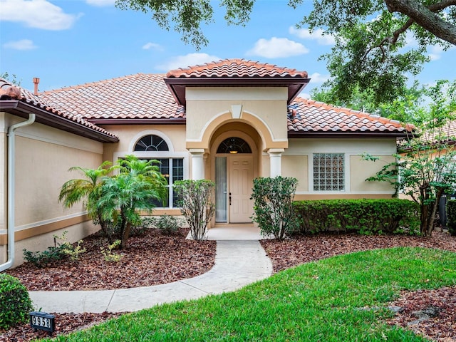 mediterranean / spanish-style house featuring a tiled roof and stucco siding