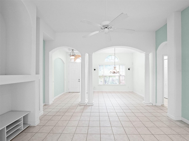 interior space featuring arched walkways, light tile patterned flooring, a ceiling fan, and ornate columns