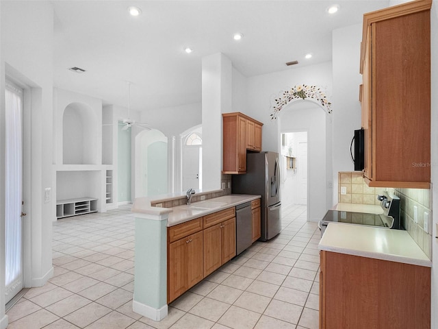 kitchen featuring decorative backsplash, light tile patterned floors, a sink, and stainless steel appliances