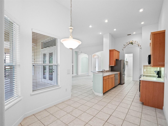 kitchen featuring arched walkways, light countertops, appliances with stainless steel finishes, recessed lighting, and light tile patterned flooring