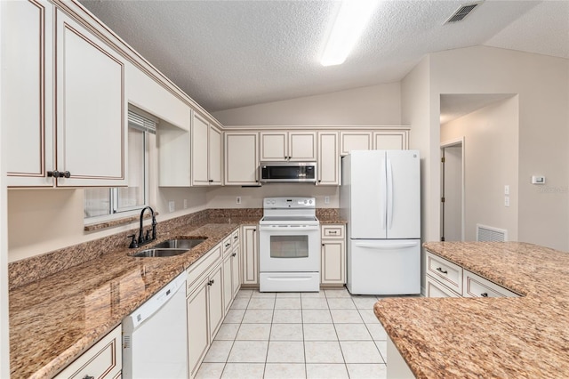 kitchen featuring light stone countertops, sink, white appliances, vaulted ceiling, and light tile patterned flooring