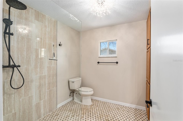 bathroom featuring toilet, a tile shower, and a textured ceiling