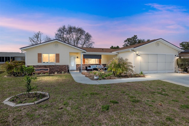 ranch-style house featuring a garage and a yard