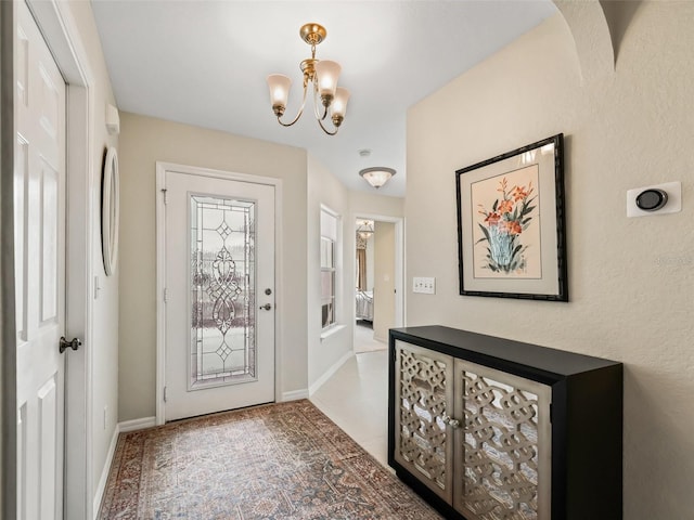 entryway with tile patterned floors and a notable chandelier