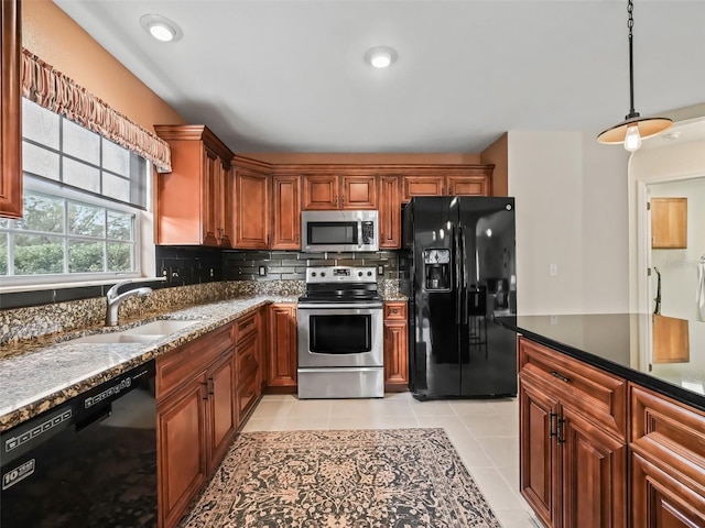 kitchen featuring sink, light tile patterned floors, black appliances, decorative backsplash, and dark stone counters