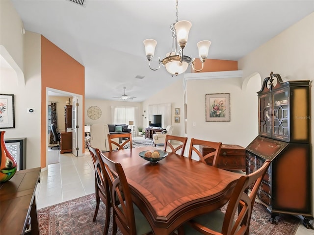 tiled dining room with vaulted ceiling and ceiling fan with notable chandelier