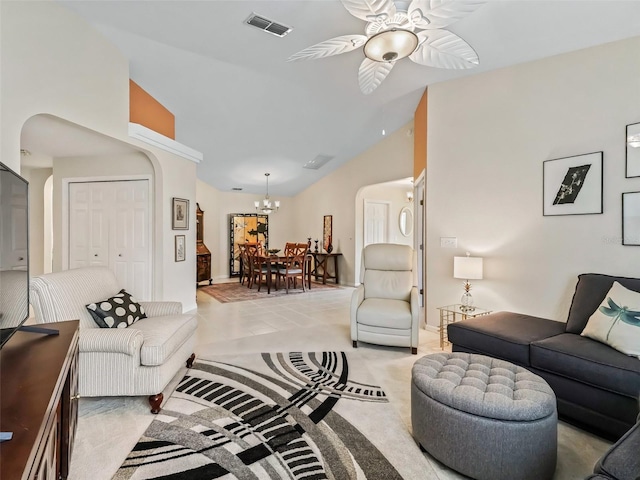 carpeted living room featuring high vaulted ceiling and ceiling fan with notable chandelier