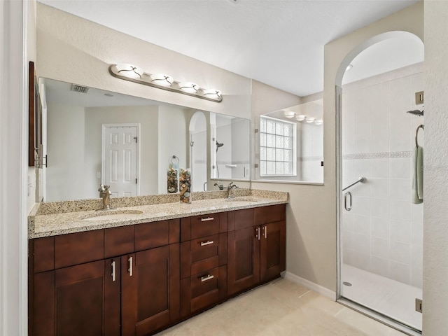 bathroom with tile patterned flooring, vanity, and a shower with shower door