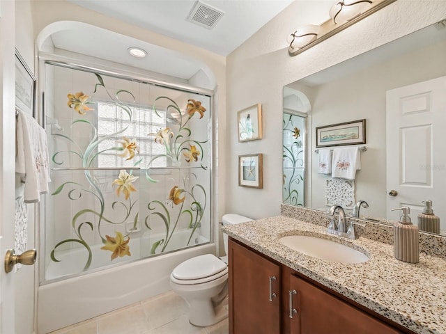 full bathroom with vanity, tile patterned floors, shower / bath combination with glass door, and toilet