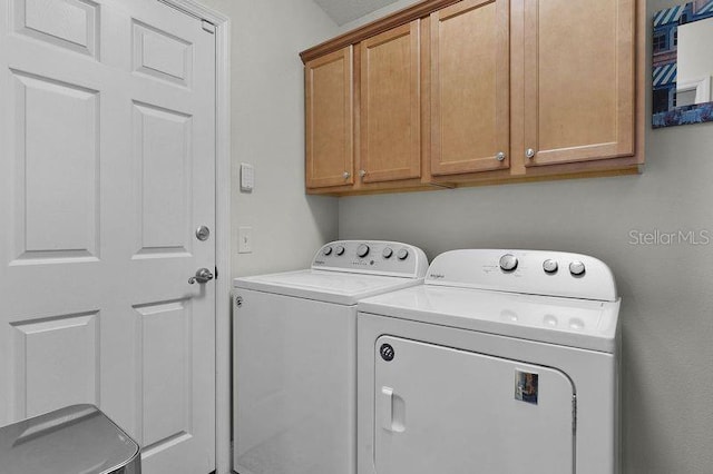 washroom featuring independent washer and dryer and cabinets