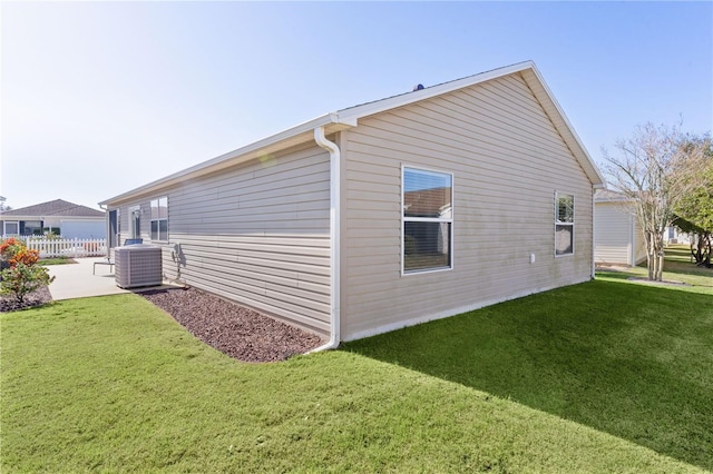 view of home's exterior with central AC unit, a patio area, and a lawn