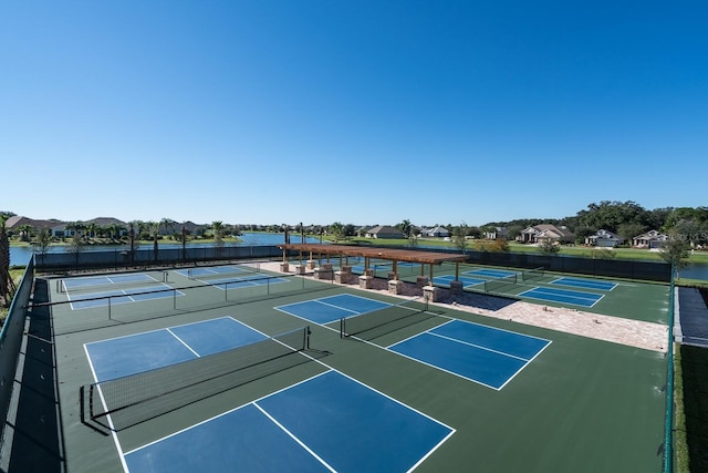 view of tennis court featuring a water view