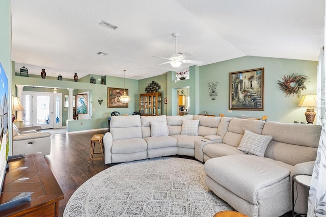 living room featuring ornate columns, vaulted ceiling, dark wood-type flooring, and ceiling fan