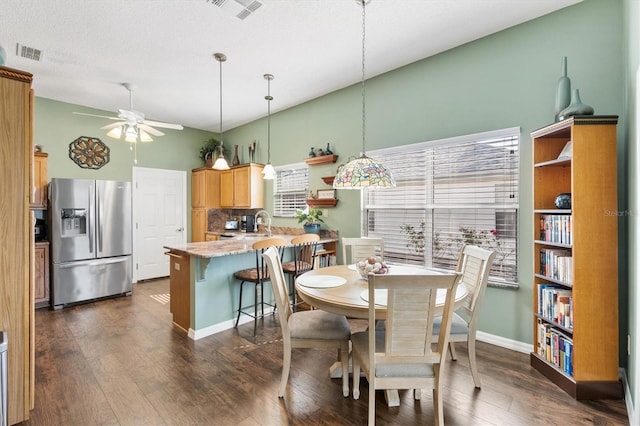 dining room featuring sink, ceiling fan, dark wood-type flooring, and a textured ceiling