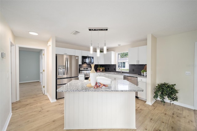 kitchen featuring white cabinetry, a center island, and appliances with stainless steel finishes