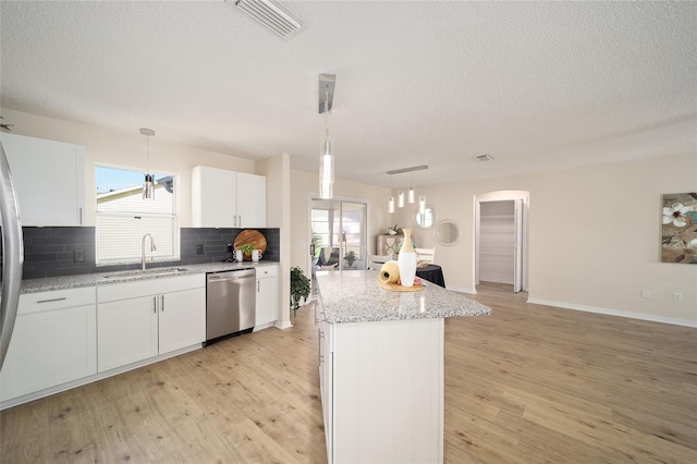 kitchen with sink, decorative light fixtures, a center island, stainless steel appliances, and white cabinets