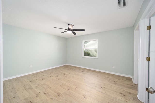 unfurnished room with ceiling fan, a textured ceiling, and light wood-type flooring
