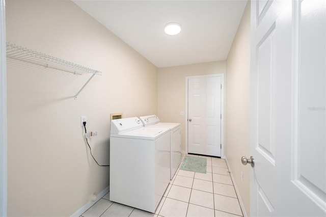washroom with light tile patterned floors and washer and dryer