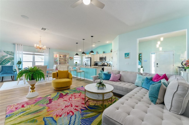 6576 Merrill Ln, The Villages, FL 34762 - living room featuring vaulted ceiling, ceiling fan with notable chandelier, visible vents, light wood-style floors, and recessed lighting