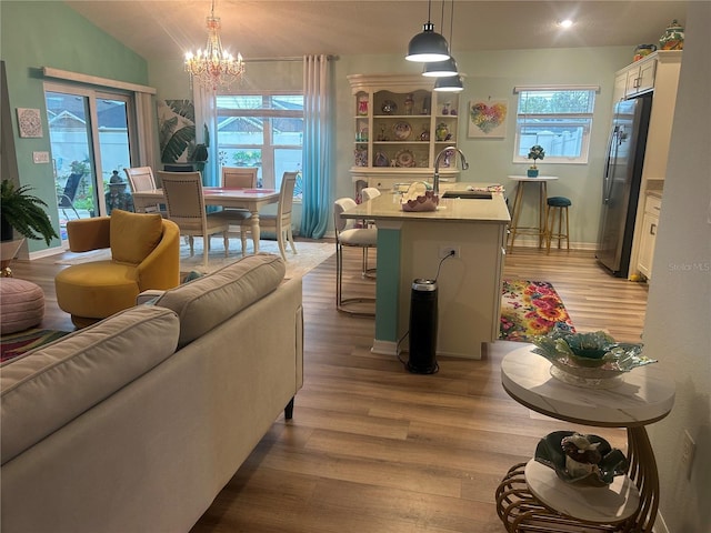 6576 Merrill Ln, The Villages, FL 34762 - living room with vaulted ceiling, baseboards, a chandelier, and wood finished floors