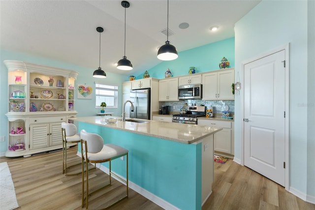 6576 Merrill Ln, The Villages, FL 34762 - kitchen featuring light wood-style flooring, a kitchen breakfast bar, a sink, and stainless steel appliances